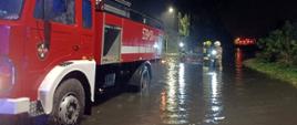 Zdjęcie przedstawia strażaków podczas działań dot. lokalnych podtopień. 