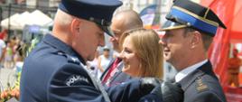 Zdjęcie przedstawia Komendanta Policji wręczającego odznaczenie Komendantowi Państwowej Straży Pożarnej.