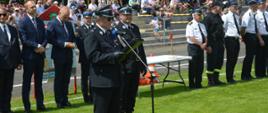 XI Powiatowe Zawody Sportowo-Pożarnicze OSP i MDP. Stadion w Miejskiej Górce. Na tle gości, komisji sędziowskiej i trybun, na których zasiadają kibice, do zebranych przemawia prezes ZOP ZOSP RP w Rawiczu. 
