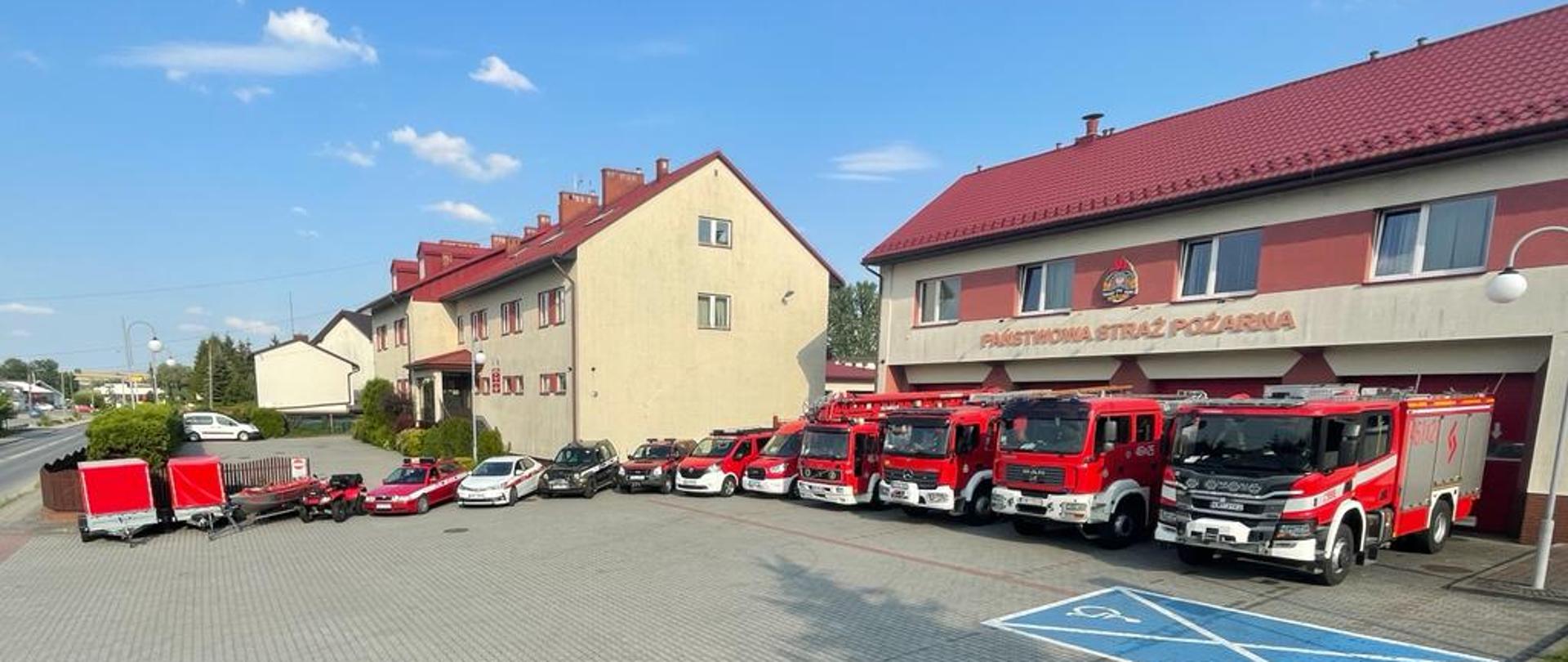 Na zdjeciu widoczne pojazdy pożarnicze inne na tle budnów JRG i KP PSP Miechów
