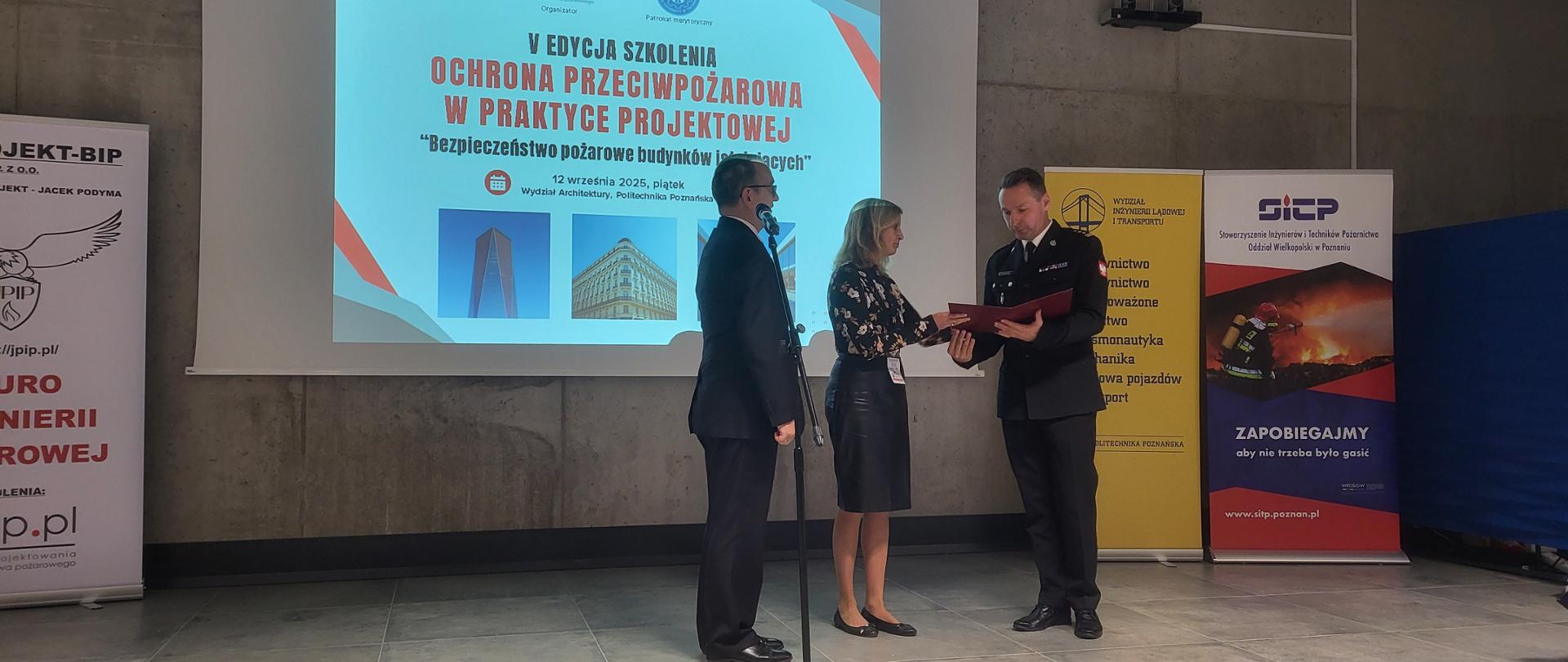 Zastępca Wielkopolskiego Komendanta Wojewódzkiego st. bryg. Tomasz Wiśniewski wygłasza prelekcję, nt. „Aby budowanie nie podejmowało szkody od ognia”.