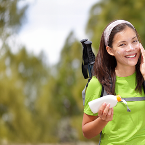 kobieta smaruje twarz kremem z filtrem UV