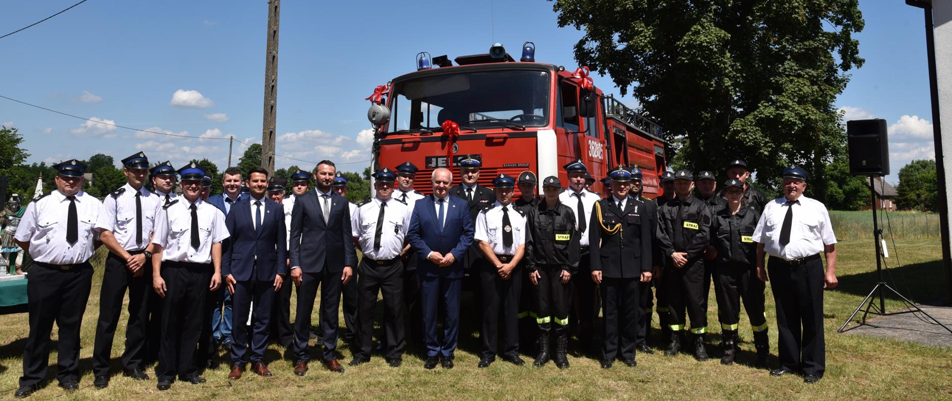 Wspólne zdjęcie z druhami OSP Gościmiec i gośćmi uroczystości przy przekazanym samochodzie 