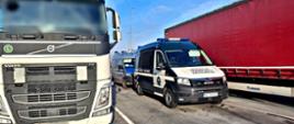 Pojazdy Inspekcji Transportu Drogowego i Policji stojące obok ciężarówek podczas kontroli drogowej na parkingu