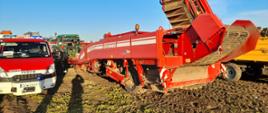 Na polu stoi pojazd straży pożarnej traktor oraz kombajn do warzyw