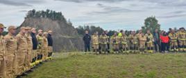 strażacy stoją na zbiórce, w tle Wilcza Góra