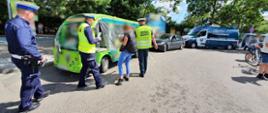 Inspektor ITD i funkcjonariusze Policji kontrolują wolnobieżny pojazd turystyczny w Ustroniu Morskim. Za nim stoi nieoznakowany radiowóz Policji i oznakowany furgon ITD.