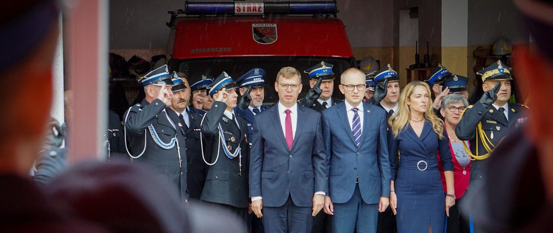 Strażacy razem z Wojewodą i Wiceministrem i Panią Burmistrz Gołdapi stoją i pozują do zdjęcia 