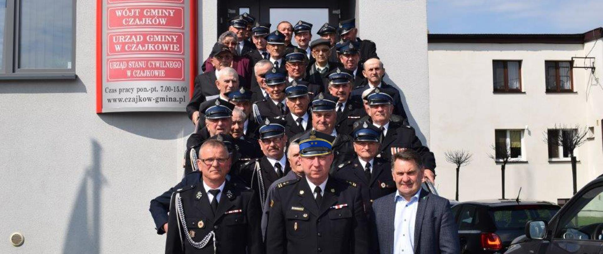 Na zdjęciu druhowie OSP z zastępcą komendanta powiatowego PSP w Ostrzeszowie i wójtem gminy Czajków przed budynkiem urzędu.
