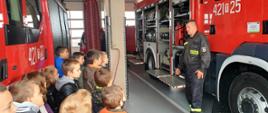 Strażacy omawiają i pokazują dzieciom sprzęt pożarniczy