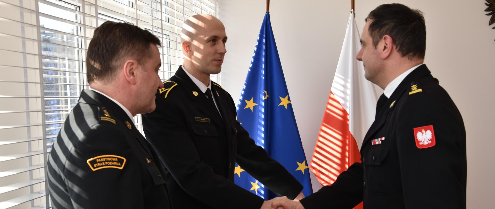 Zdjęcie przedstawia Świętokrzyskiego Komendanta Wojewódzkiego PSP gratulującego nowemu psychologowi