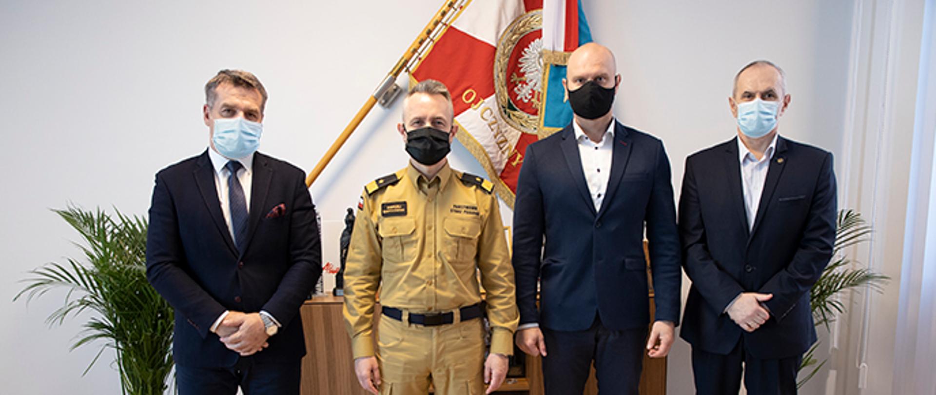 Zdjęcie grupowe. Komendant Główny nadbryg. Andrzej Bartkowiak z trzema przedstawicielami związków zawodowych w PSP.