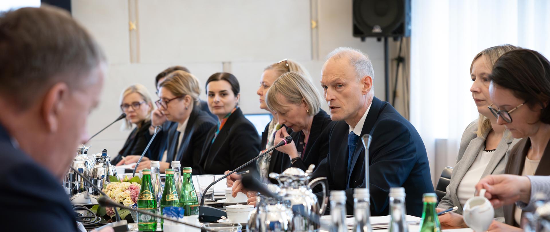 Grupa osób siedzi przy stole konferencyjnym, na pierwszym planie widać ministra Zajączkowskiego
