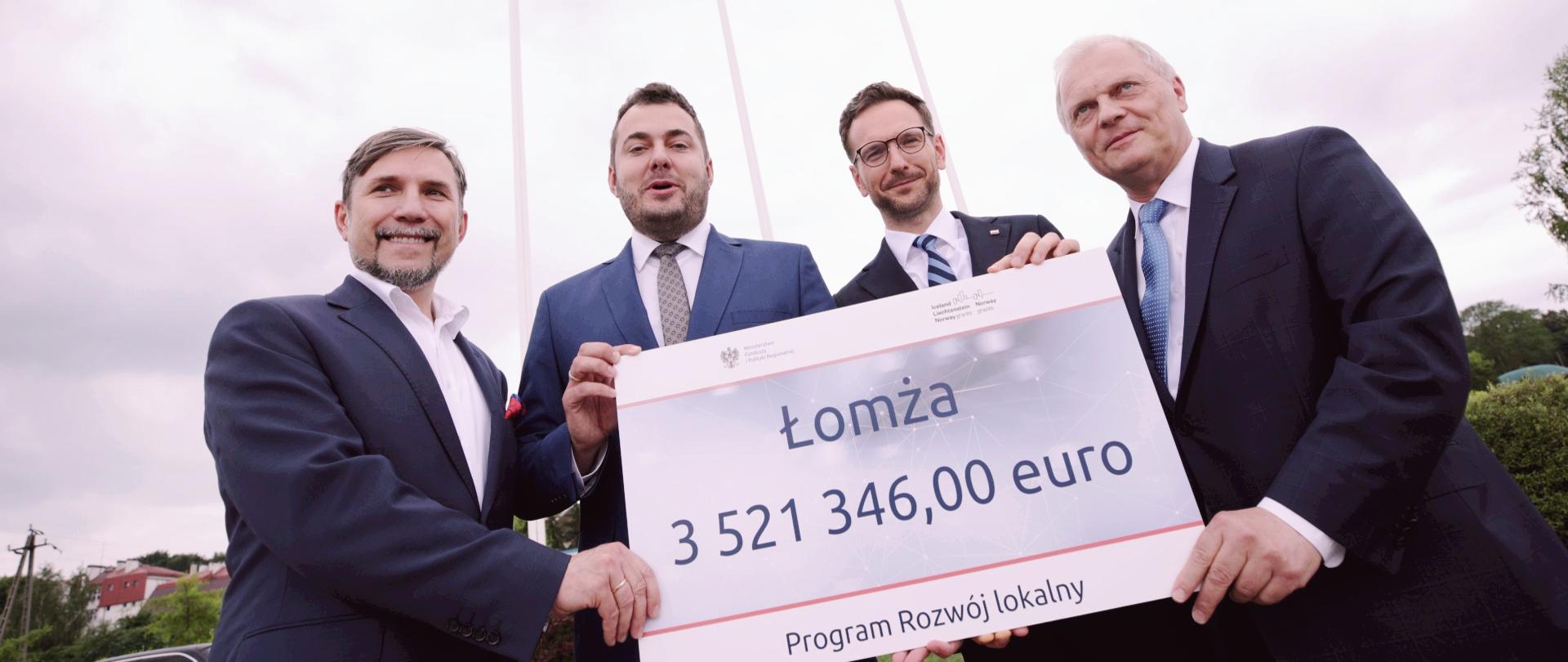 uczestnicy spotkania prezentują symboliczny czek pokazujący wartość dofinansowania