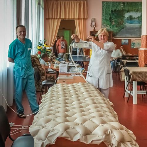 kadra medyczna prezentuje materac przeciodleżynowy z naklejką Polskiej pomocy