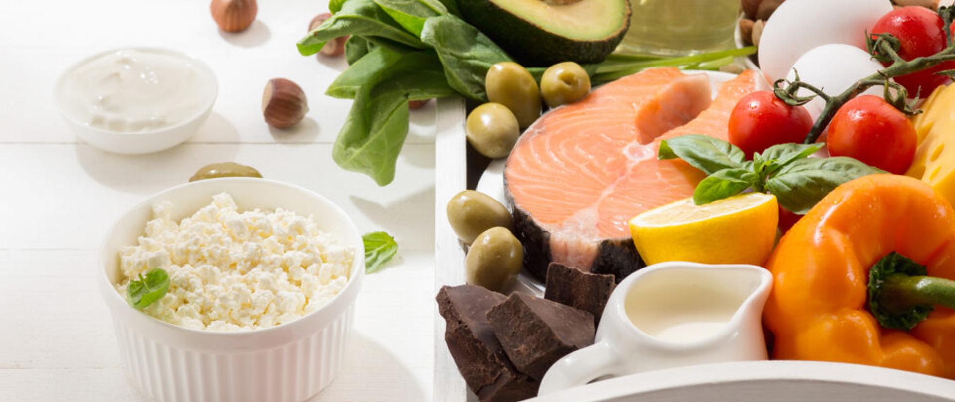 Ketogenic low carbs diet - food selection on white wooden background. Balanced healthy organic ingredients of high content of fats. Nutrition for the heart and blood vessels. Meat, fish and vegetables.