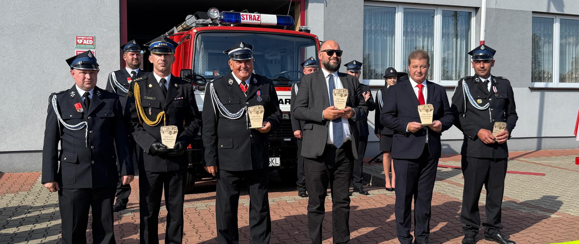 Zaproszeni goście stoją z otrzymanymi upominkami.