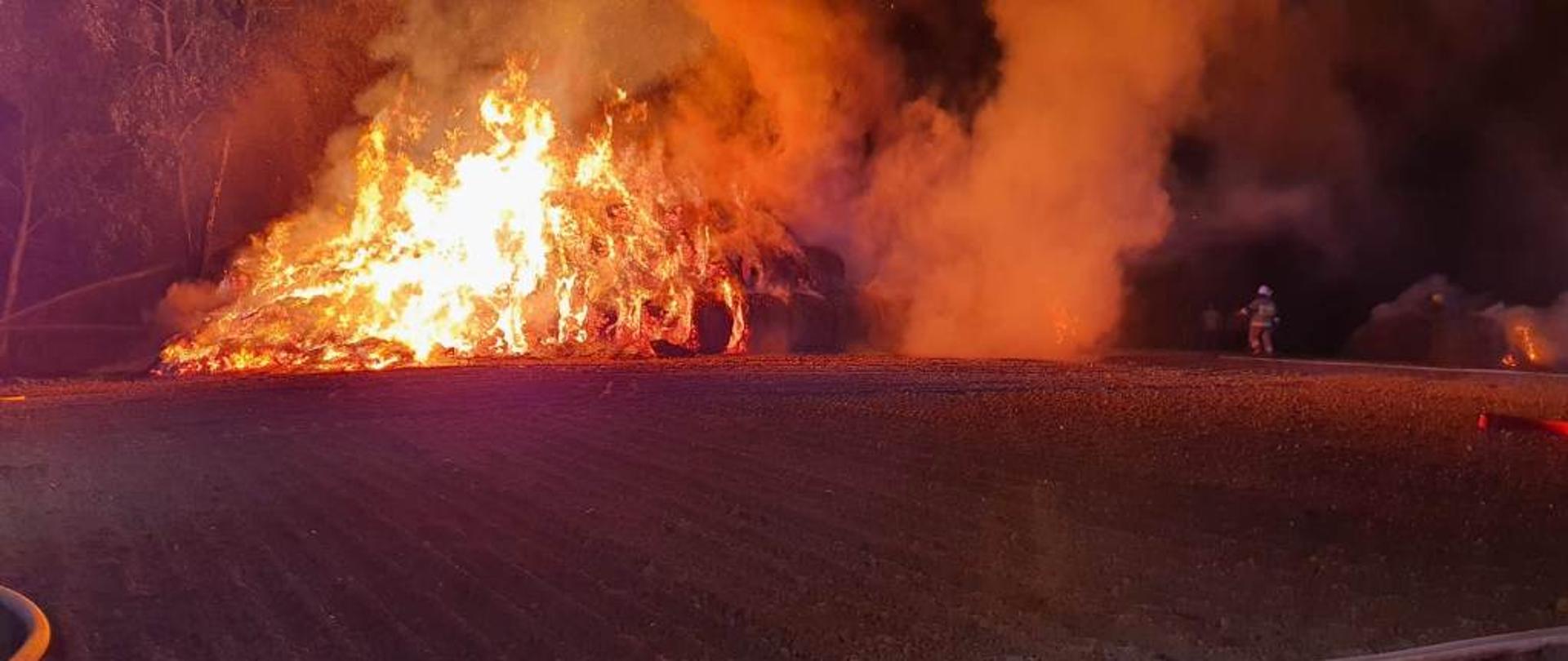 Strażacy w trakcie akcji gaśniczej balotów słomy