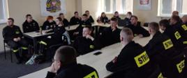 Zdjęcie przedstawia druhny i druhów z OSP z terenu powiatu obornickiego na sali wykładowej podczas wykładów. 