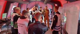 Widać kilku strażaków w namiocie, ustalają plan ćwiczeń