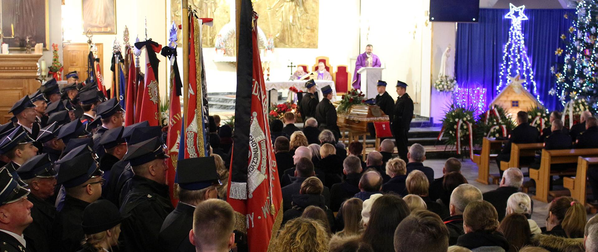 Poczty sztandarowe jednostek OSP w kościele podczas Mszy Świętej