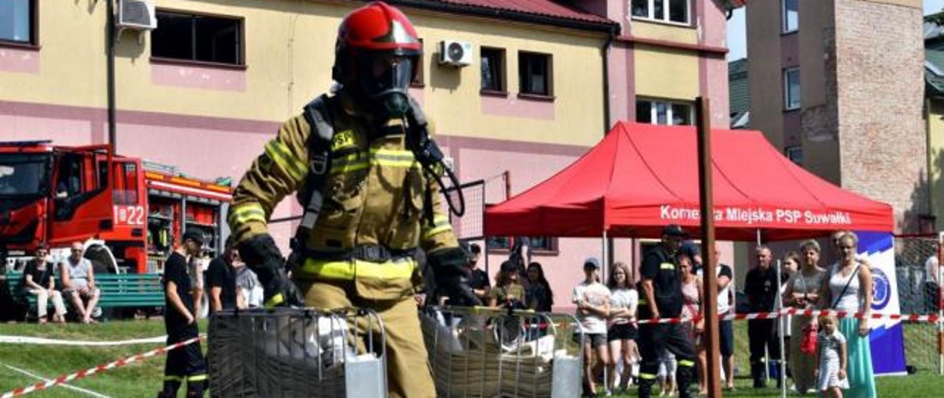 Strażak biegnie na torze w pełnym ubraniu strażackim