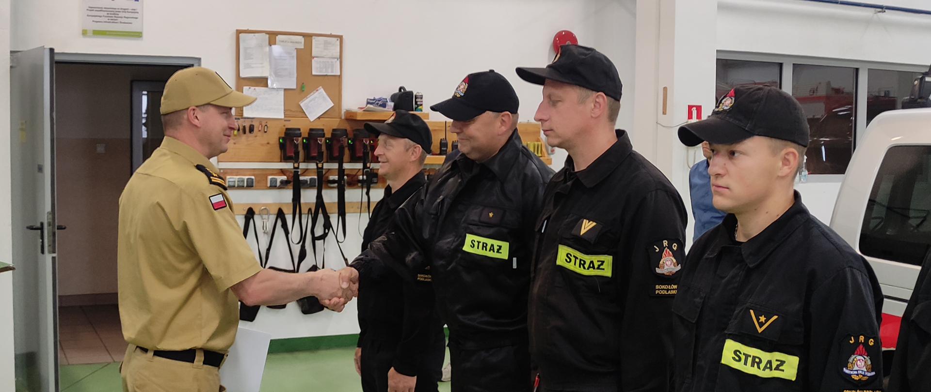 Wyróżnienie sokołowskich nurków przez Mazowieckiego Komendanta Wojewódzkiego PSP - na zdjęciu strażacy w garażu w 2 szeregach podczas wręczenia rozkazu o nagrodzie.