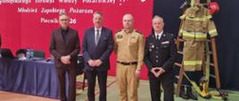 Na zdjęciu wykonanym w hali sportowej udekorowanej w strażackie akcenty ustawili się Wójt Gminy Wałcz, Wice starosta Powiatu wałeckiego, Komendant Powiatowy PSP w Wałczu oraz Komendant Gminny OSP gminy Mirosławiec. 