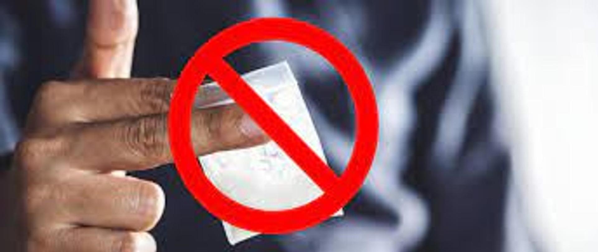 Woreczek z narkotykiem trzymany palcami, przekreślony czerwonym znakiem zakazu.