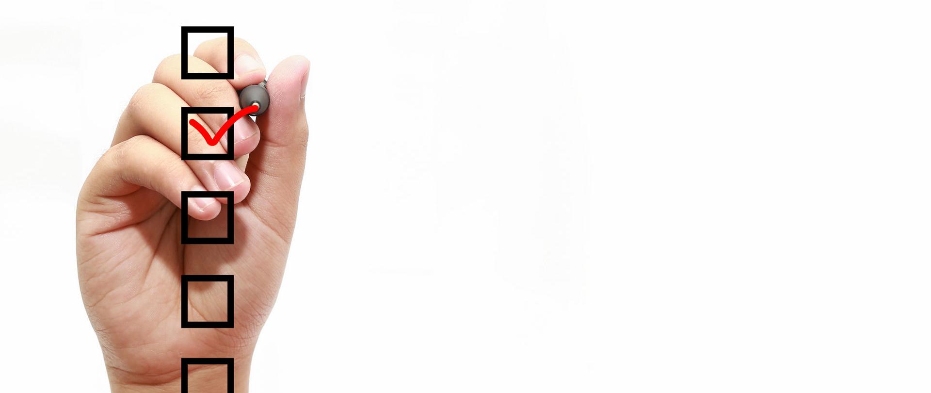 Dłoń z flamastrem, zakreśla jeden z kwadratów.