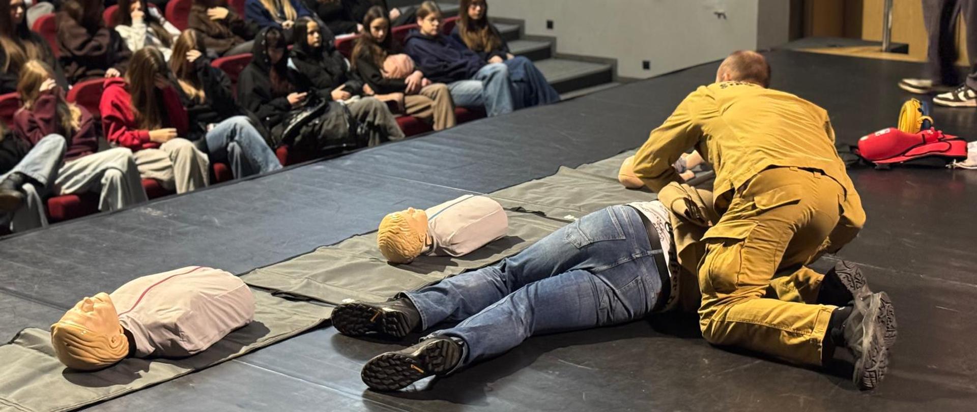 Na zdjęciu funkcjonariusz Państwowej Straży Pożarnej w Jędrzejowie, który prowadzi szkolenie z zakresu kwalifikowanej pierwszej pomocy (KPP) dla wolontariuszy WOŚP na sali kinowej w Centrum Kultury w Jędrzejowie.