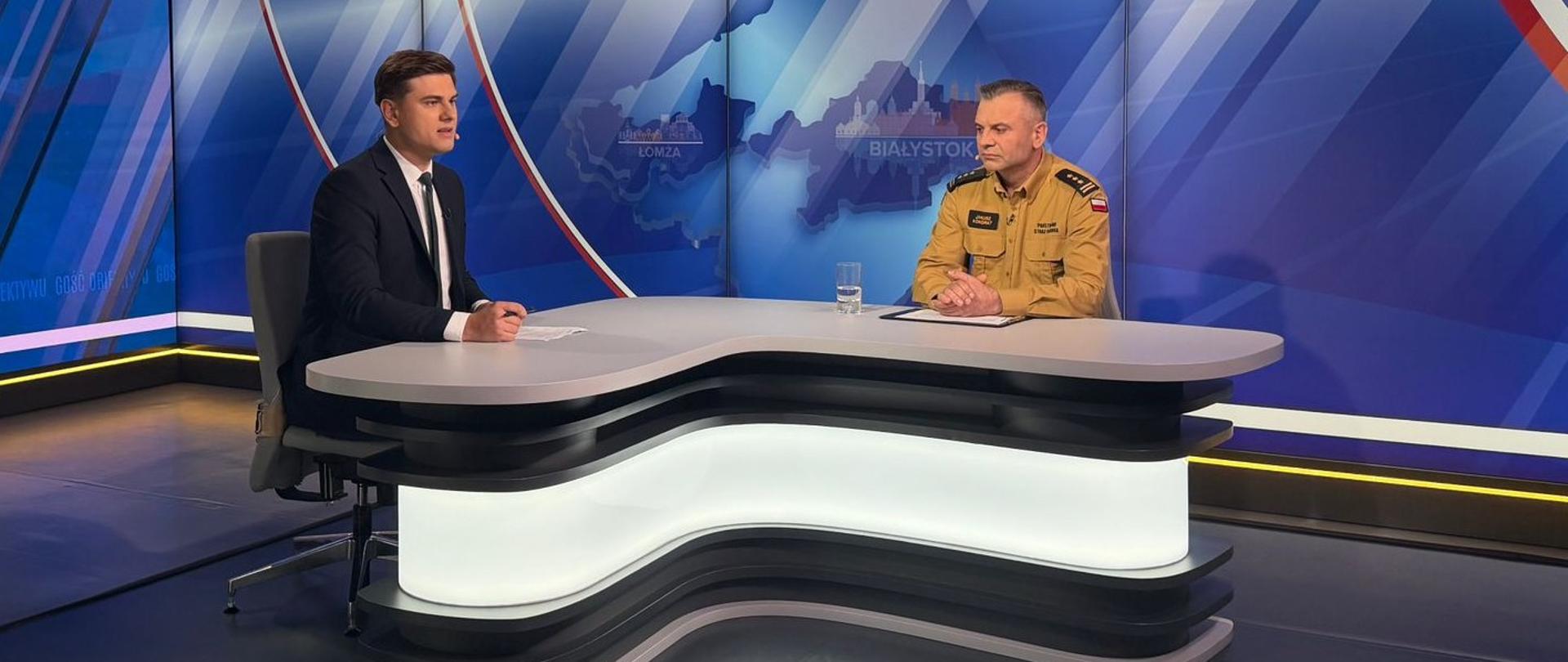 Gość Obiektywu - st. bryg. Janusz Kondrat, 02.09.2026 - program telewizyjny, redaktor oraz szef podlaskich strażaków przy stole w studiu podczas rozmowy