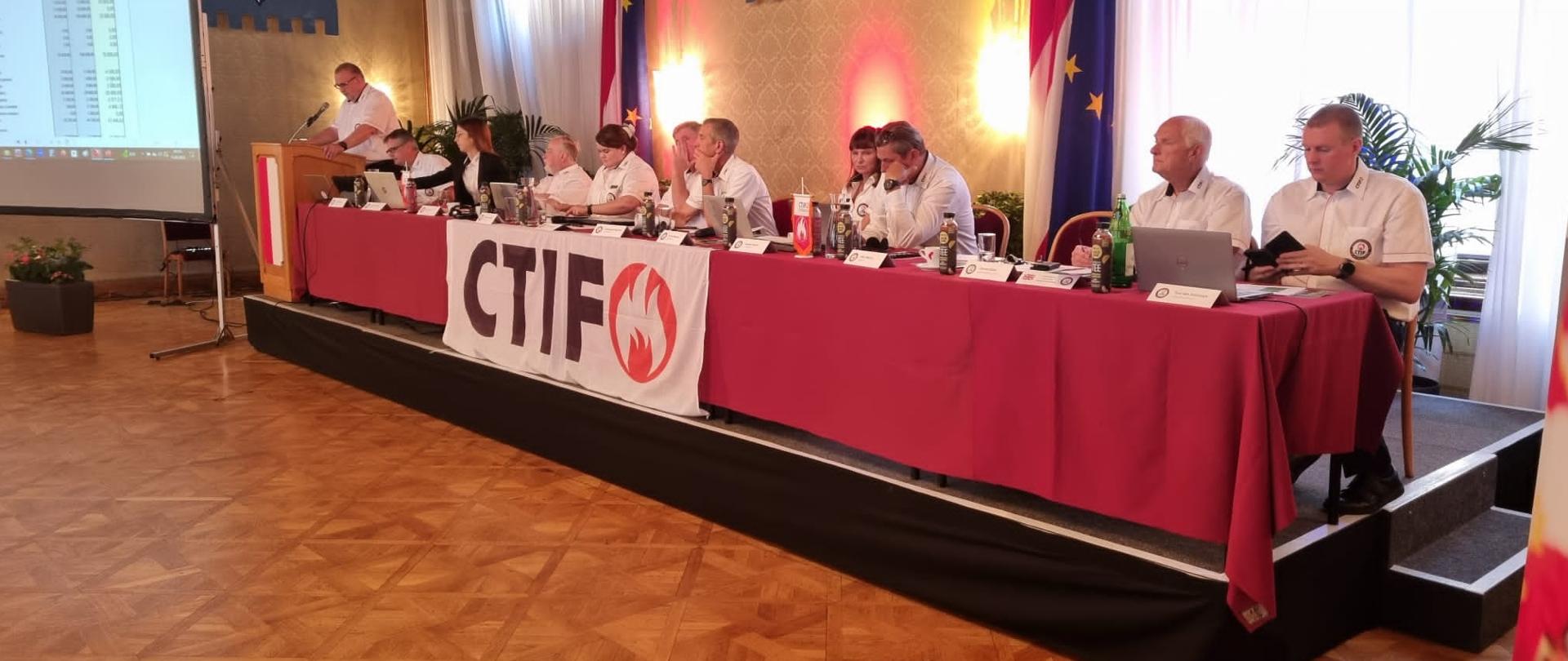 Organizatorzy spotkania podczas prezentacji przy stole konferencyjnym 