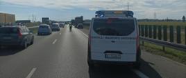 Inspektorzy z Głównego Inspektoratu Transportu Drogowego zabezpieczyli miejsce zdarzenia drogowego za pomocą oznakowanego radiowozu.