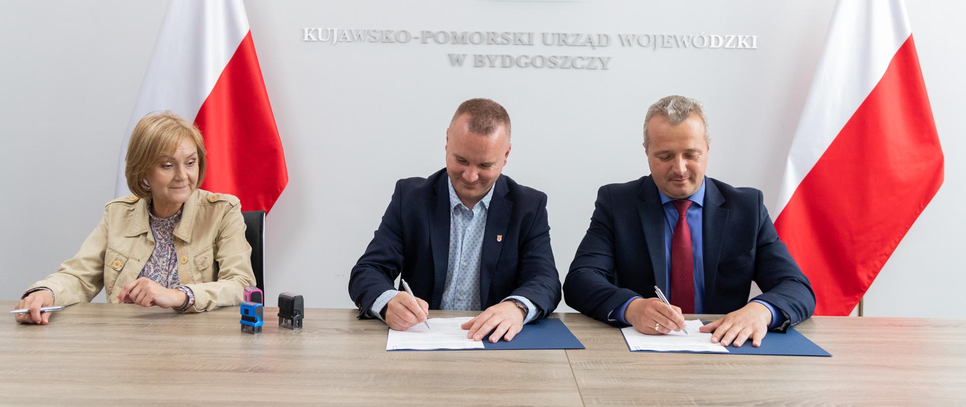 Kobieta i dwóch mężczyzn podczas podpisania umów