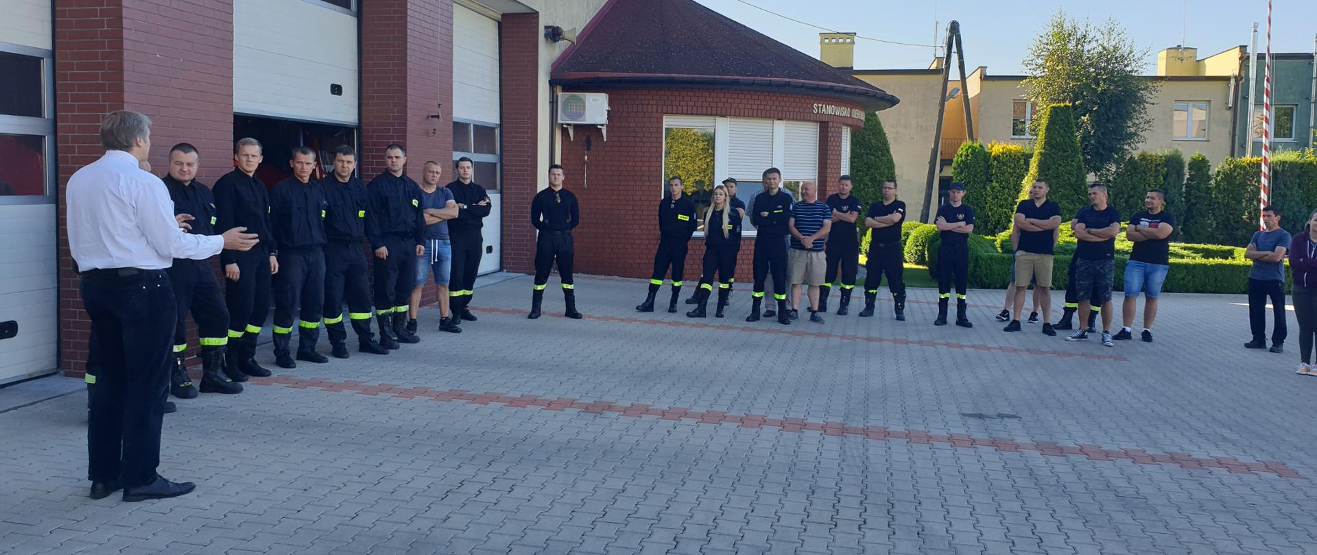 Strażacy i druhowie OSP stoją na placu Komendy podczas szkolenia