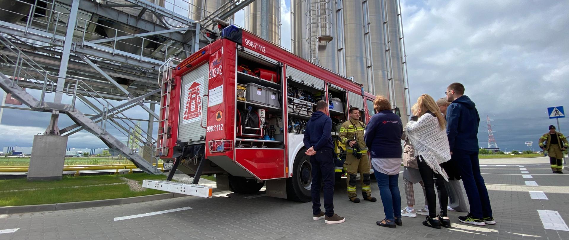 Strażacy ratownicy pokazujący wyposażenie samochodu rat-gaś