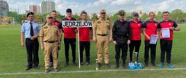 Na zdjęciu widać drużynę Komendy Powiatowej Państwowej Straży Pożarnej w Jędrzejowie, która uzyskała czwarte miejsce drużynowo w klasyfikacji generalnej mistrzostw w sporcie pożarniczym. Na zdjęciu widać także świętokrzyskiego komendanta wojewódzkiego PSP w Kielcach wraz ze swoim zastępcą oraz komendanta powiatowego PSP w Jędrzejowie. 