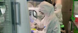 Diagnosta laboratoryjny w stroju ochronnym. 