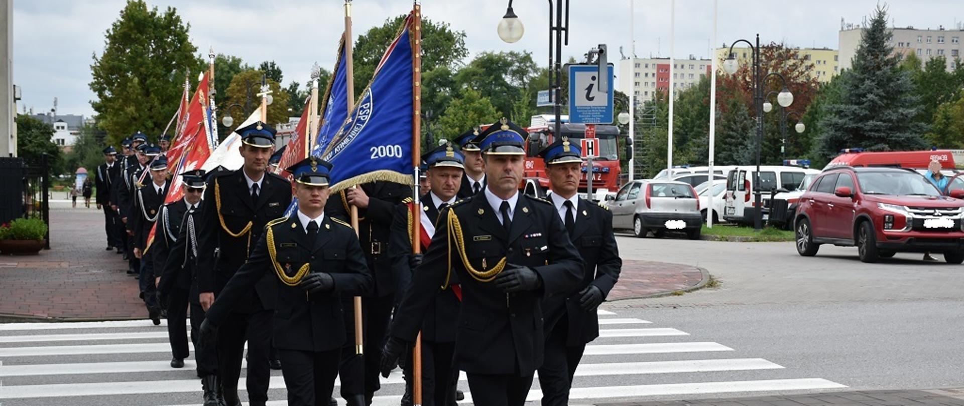Zdjęcie obrazuje uformowany pododdział strażaków, który jest prowadzony przez Zastępcę Komendanta Powiatowego PSP w Skarżysku-Kamiennej st. kpt. Marcin Jasińskiego. W pododdziale znajdują się strażacy Państwowej Straży Pożarnej oraz druhowie Ochotniczych Straży Pożarnych z terenu powiatu skarżyskiego. 