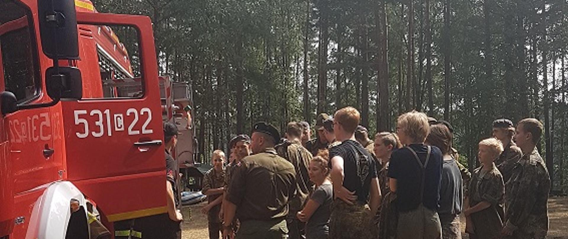 na zdjęciu funkcjonariusze Komendy Powiatowej Państwowej Straży Pożarnej w Świeciu podczas omawiania zasad bezpieczeństwa podczas wakacji, w lesie i nad wodą