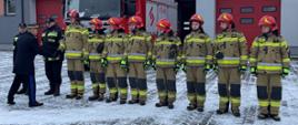 Na zdjęciu widać strażaków stojących w szeregu.
