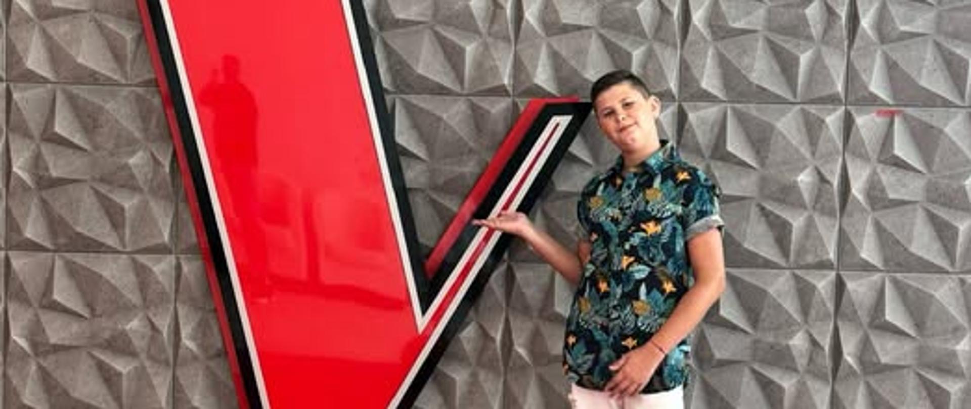 Na plakacie w górnej jego części znajduje się zdjęcie Przedstawiające chłopca wskazującego na dużą czerwoną literę V, która jest jednocześnie logo programu. Na zdjęciu w górnej jego części znajduje się napis Stanisław Pilarzewicz The Voice Kids 8.
W dolnej części plakatu znajduje się czerwony szeroki pas a na nim napis: 22.02 sobota 20:00 TVP2.