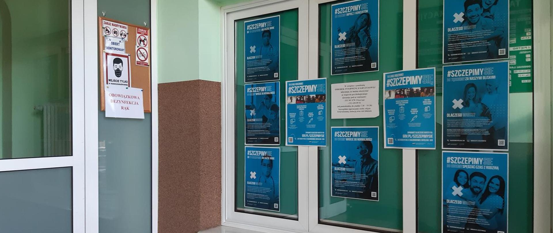 Akcja #SZCZEPIMYSIĘ w PSSE Bytom. Plakaty akcji rozwieszone w holu wejścia głównego.