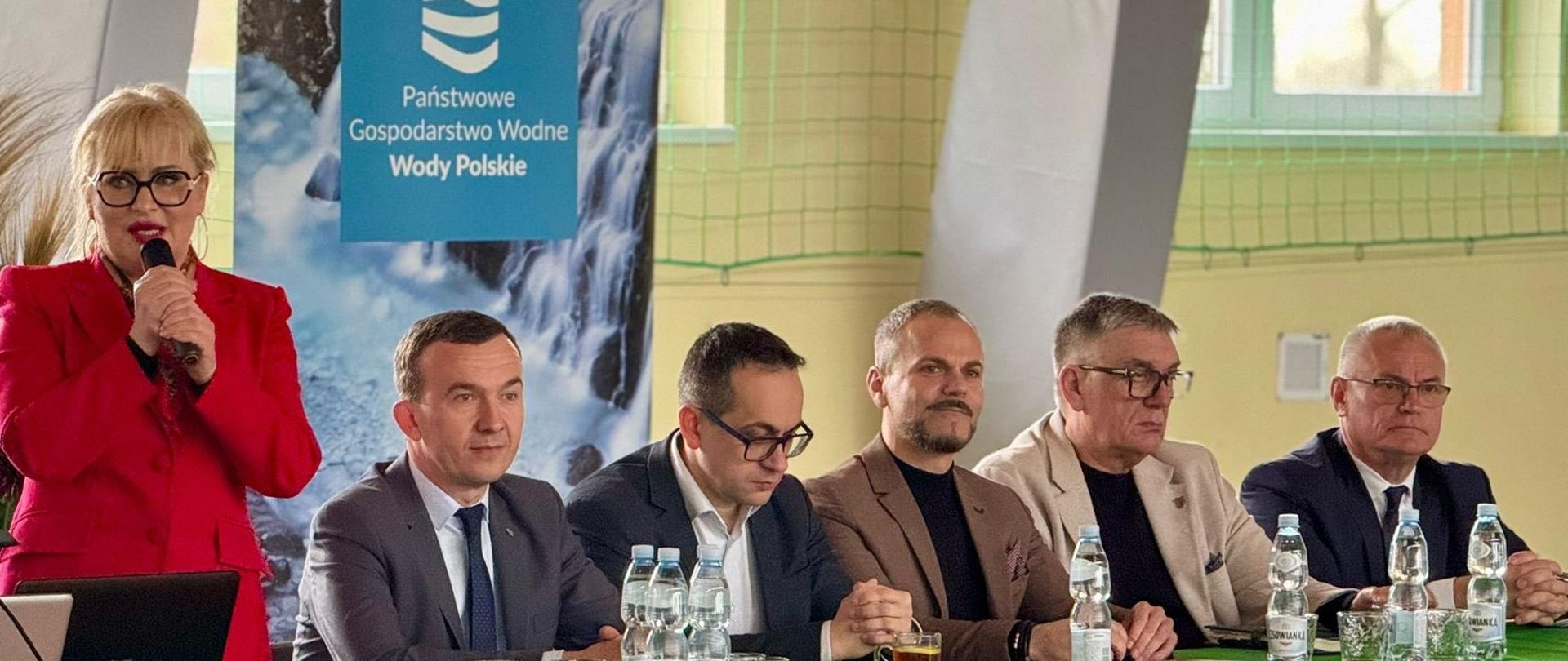 Posiedzenie Żuławskiego Zespołu Parlamentarnego: obrady, kobieta przemawia, przy stole prezydialnym kilka osób, wśród nich wicewojewoda Mateusz Szauer.