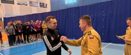 Strażak z KP PSP w Nidzicy odbiera dyplom za udział w eliminacjach.