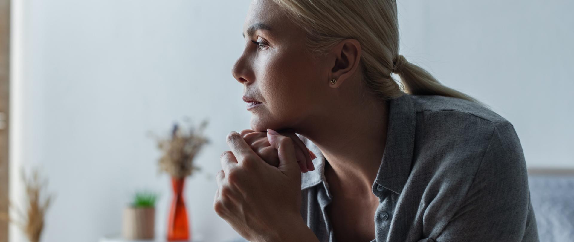 Na zdjęciu jest kobieta siedząca na łóżku.
