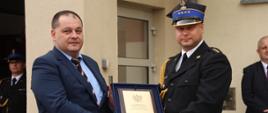 Komendant Powiatowy przyjmuje pamiątkowy prezent od przedstawiciela Wojewody Zachodniopomorskiego.