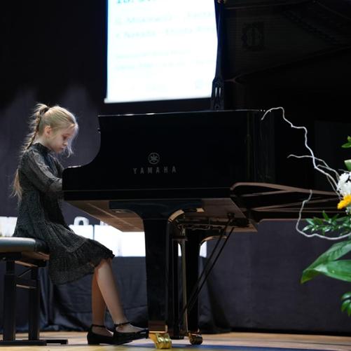 Uczennica grająca na fortepianie w sali koncertowej w Libiążu