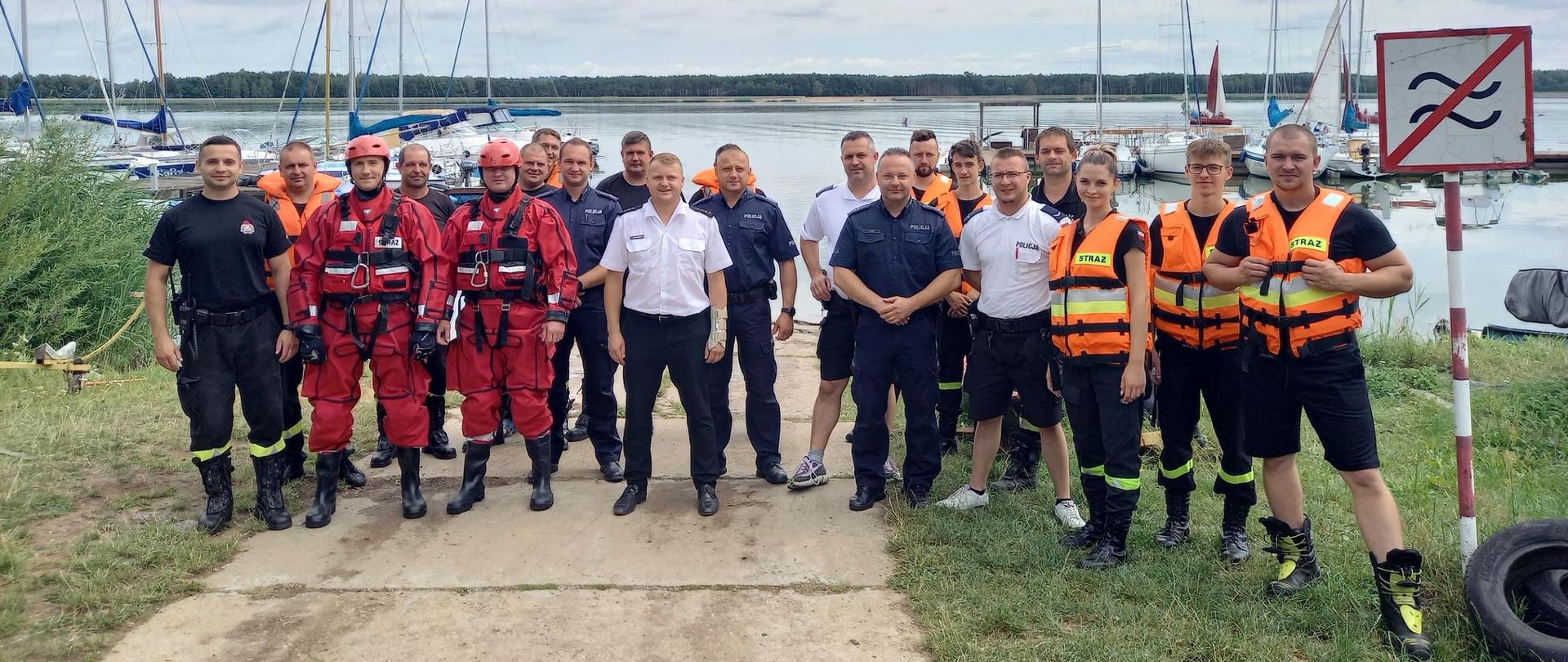 Zdjęcie przedstawia funkcjonariuszy Policji, Straży Pożarnej podczas ćwiczeń z ratownictwa wodnego.